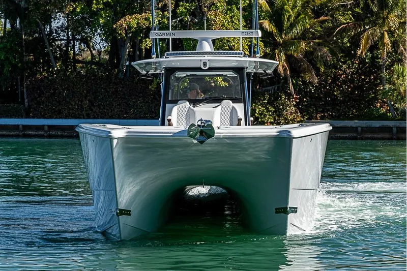 Slide: The Image of 2023 Freeman 47 boat cruising on water, featuring Garmin equipment, surrounded by lush greenery. - 21