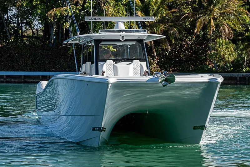 Slide: The Image of 2023 Freeman 47 boat cruising on a sunny day, surrounded by lush greenery. - 22