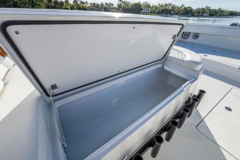 Slide: The Image of Open storage compartment on 2023 Freeman 47 boat, featuring rod holders and scenic waterfront view. - 32