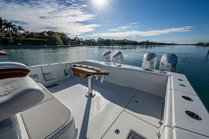Slide: The Image of 2023 Freeman 47 boat deck with seating, fishing rod holders, and outboard motors on a sunny day. - 39
