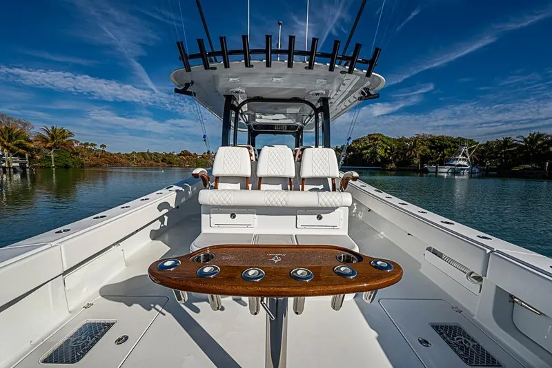 Slide: The Image of 2023 Freeman 47 boat interior with seating and rod holders on a sunny day. - 45