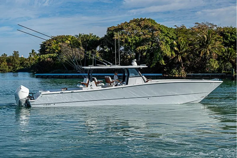 Slide: The Image of 2023 Freeman 47 boat cruising on a serene waterway with lush greenery. - 5