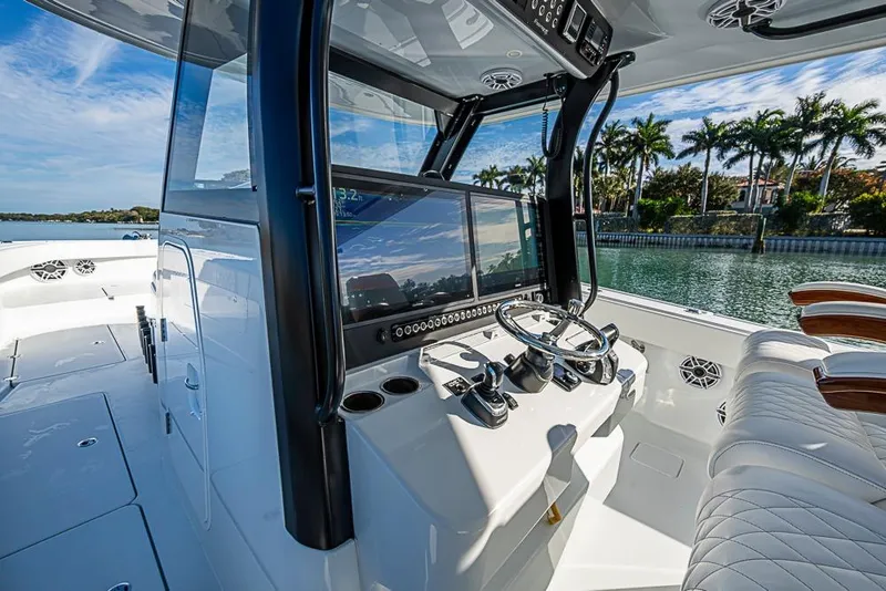 Slide: The Image of 2023 Freeman 47 boat cockpit with modern controls and luxurious seating by the water. - 57