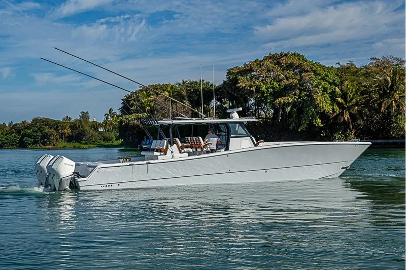 Slide: The Image of 2023 Freeman 47 boat cruising on a serene waterway with lush greenery. - 6