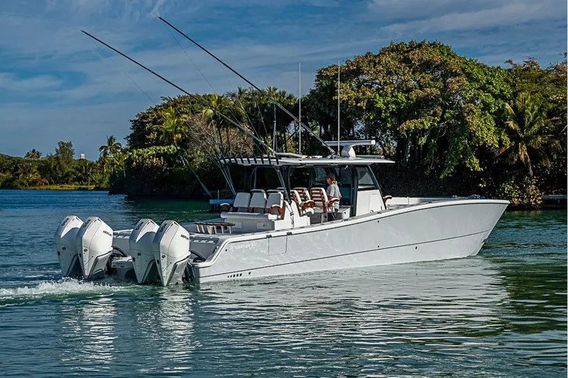 Slide: The Image of 2023 Freeman 47 boat cruising on a serene waterway with lush greenery. - 7