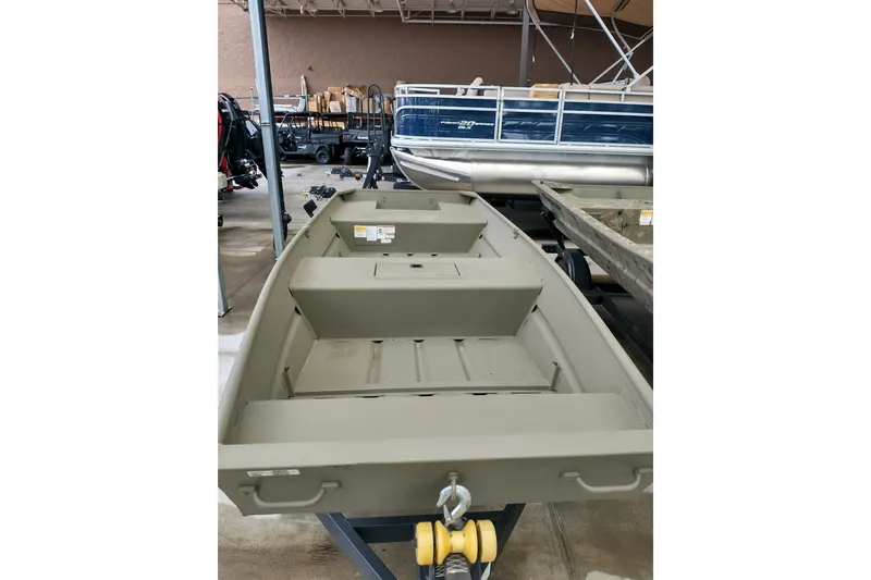 Slide: The Image of 2026 Tracker Grizzly 15 Jon boat in showroom, showcasing durable design and spacious interior. - 2