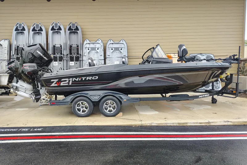 The Image of 2026 Nitro ZV21 Pro fishing boat on trailer, displayed outdoors with Mercury engine. - 0