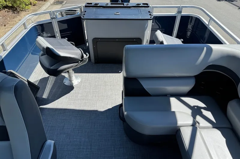 Slide: The Image of 2026 Sun Tracker SportFish 22 DLX pontoon boat interior with seating and helm. - 6