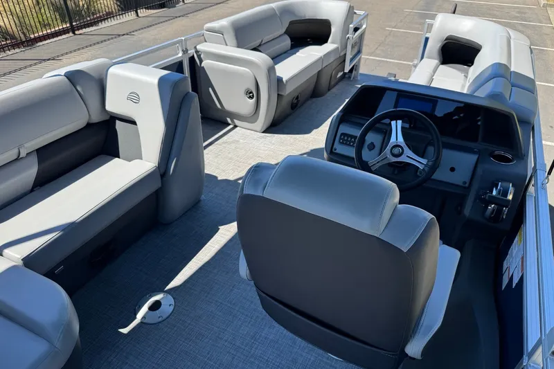 Slide: The Image of 2026 Sun Tracker SportFish 22 DLX pontoon boat interior with gray seating and steering console. - 9