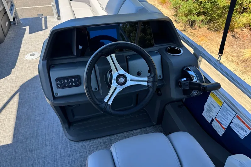 Slide: The Image of 2026 Sun Tracker SportFish 22 DLX boat dashboard with steering wheel and controls. - 7