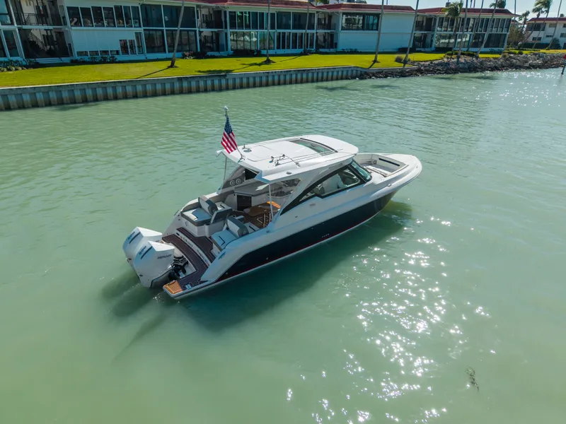 The Image of 2023 Tiara Yachts 34 LX on calm water near buildings. - 0