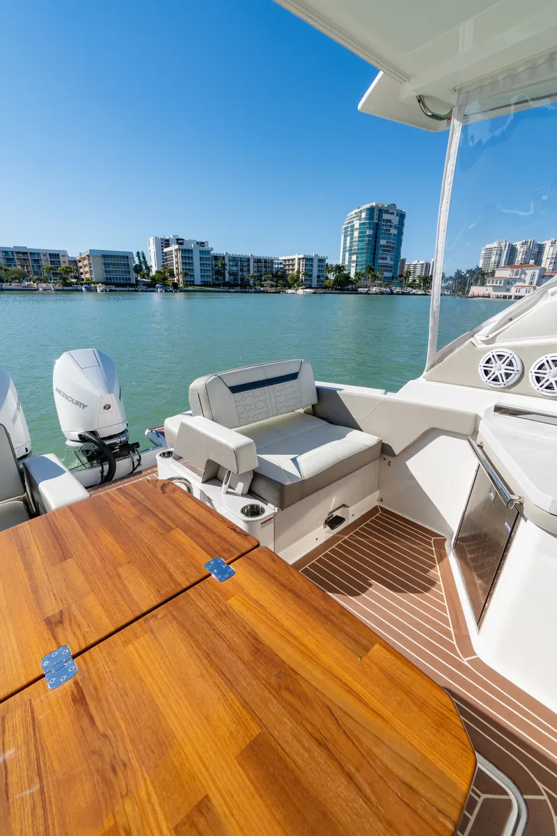 Slide: The Image of 2023 Tiara Yachts 34 LX with wooden table and water view. - 25