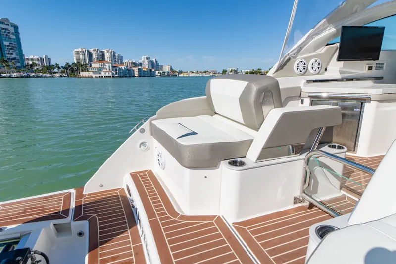 Slide: The Image of 2023 Tiara Yachts 34 LX on calm waters with cityscape view. - 38