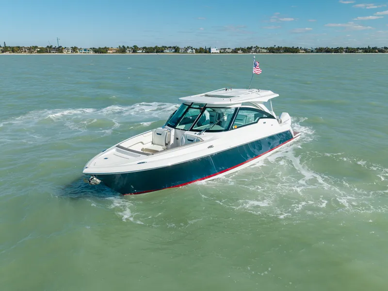 Slide: The Image of 2023 Tiara Yachts 34 LX on calm water with flag. - 8