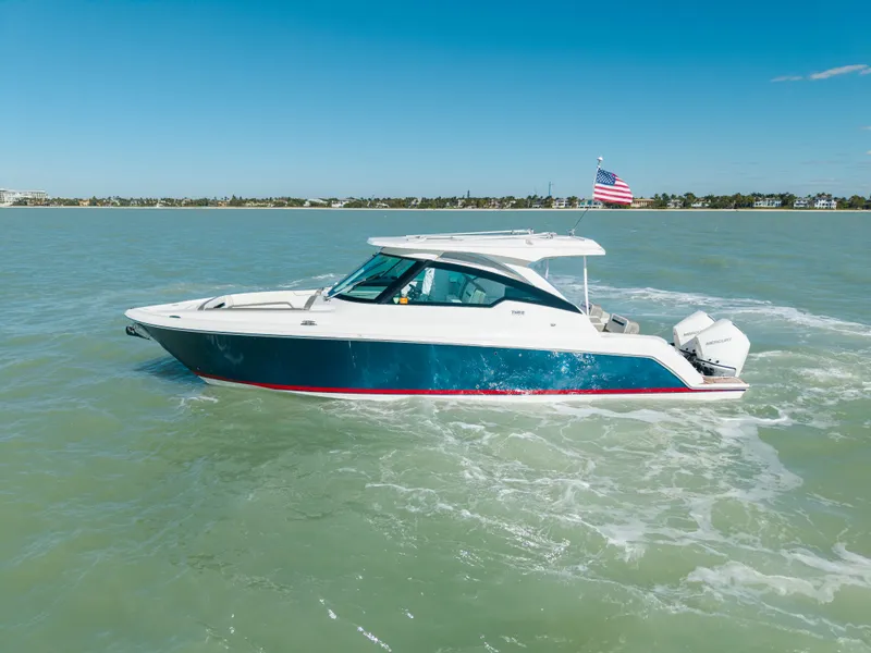 Slide: The Image of 2023 Tiara Yachts 34 LX on calm waters with American flag. - 9
