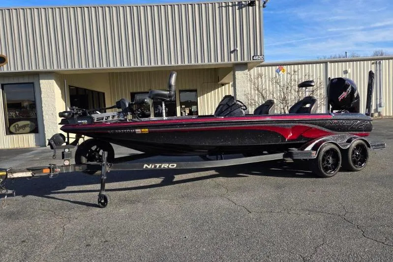 Slide: The Image of 2020 Nitro Z21 boat on trailer, parked outside a building under clear blue sky. - 1