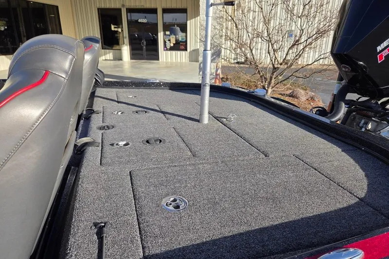 Slide: The Image of 2020 Nitro Z21 boat deck with storage compartments and seating, parked outside a building. - 12