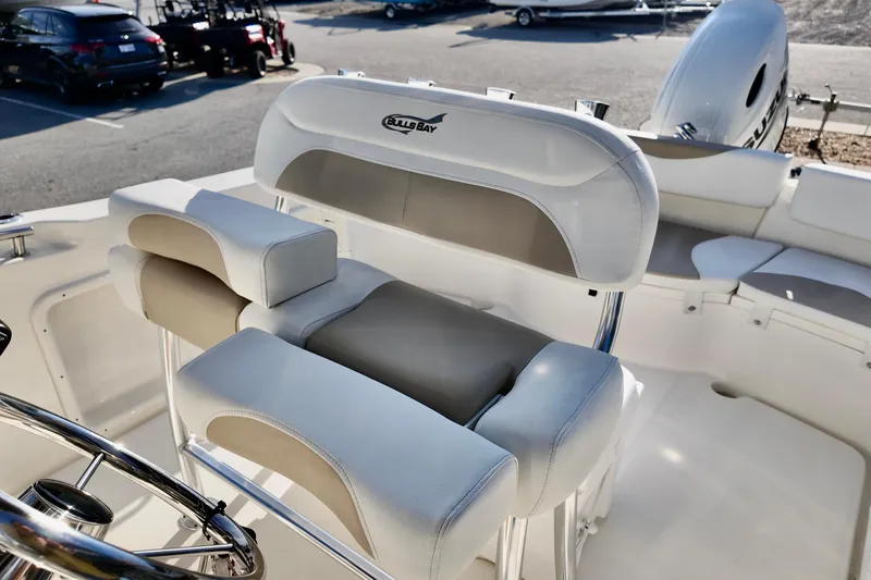 Slide: The Image of 2026 Bulls Bay 230 Center Console boat interior with cushioned seating and steering wheel. - 11