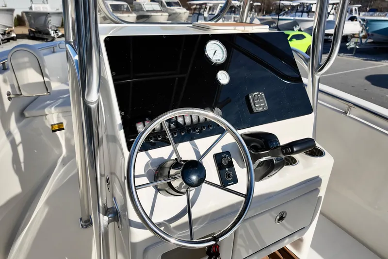 Slide: The Image of 2026 Bulls Bay 230 Center Console boat dashboard with steering wheel and controls. - 18