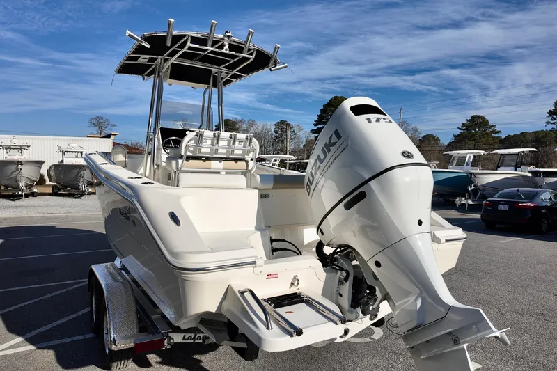 Slide: The Image of 2026 Bulls Bay 230 Center Console boat with Suzuki 175 engine, parked outdoors. - 2