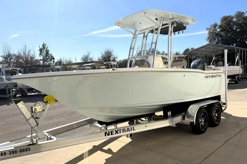 Slide: The Image of 2024 Key West 203 FS boat on trailer, parked outdoors under clear sky. - 4