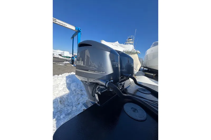 Slide: The Image of 2011 Regulator 28 Forward Seating boat with Yamaha outboard engines in a snowy marina. - 11