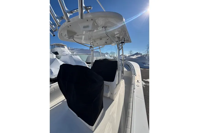 Slide: The Image of 2011 Regulator 28 Forward Seating boat with covered seats, under a clear blue sky. - 12