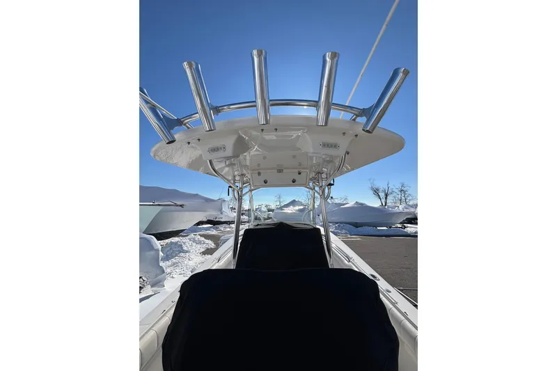 Slide: The Image of 2011 Regulator 28 Forward Seating boat with T-top and rod holders, parked in snowy setting. - 15