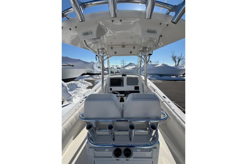 Slide: The Image of 2011 Regulator 28 Forward Seating boat interior with helm and seating, under clear blue sky. - 16
