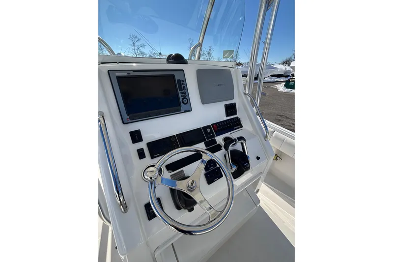 Slide: The Image of 2011 Regulator 28 Forward Seating boat dashboard with steering wheel and navigation controls. - 18