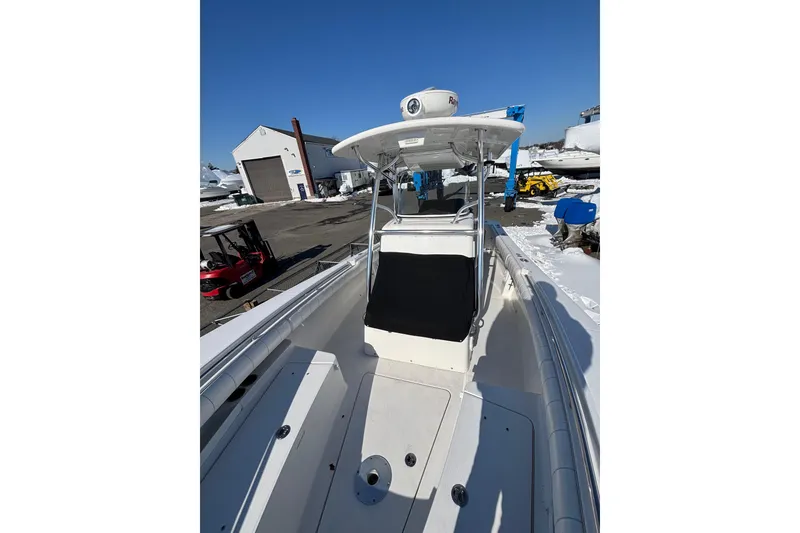 Slide: The Image of 2011 Regulator 28 Forward Seating boat in a marina, showcasing spacious deck and seating. - 29