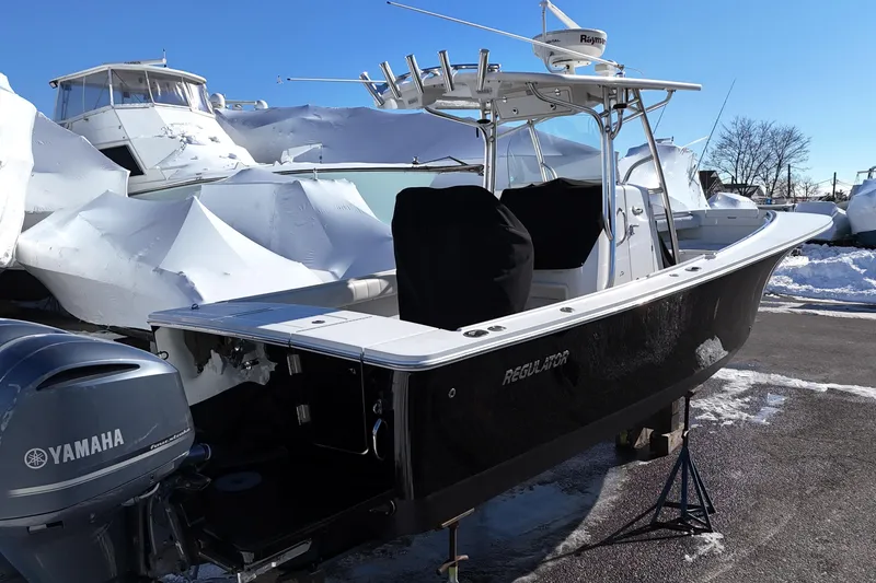 Slide: The Image of 2011 Regulator 28 Forward Seating boat with Yamaha engine, parked in snowy marina. - 3