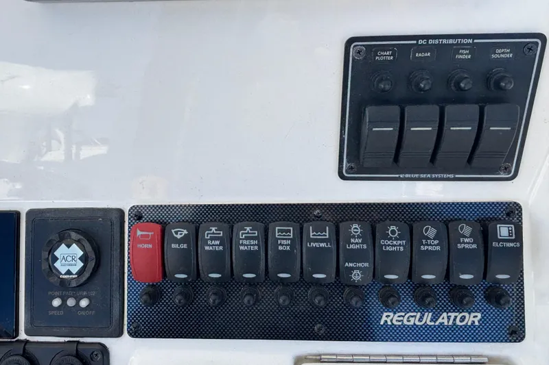 Slide: The Image of Control panel of a 2011 Regulator 28 Forward Seating boat with various switches. - 32