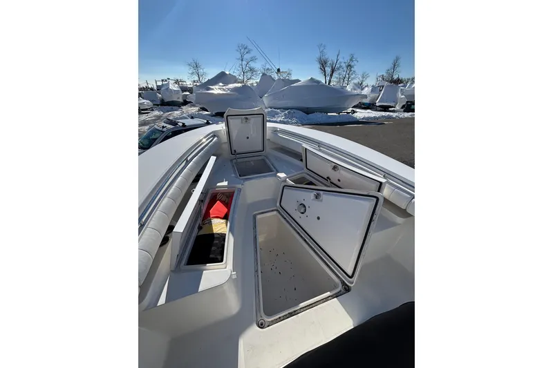 Slide: The Image of 2011 Regulator 28 Forward Seating boat with open storage compartments, parked outdoors. - 37