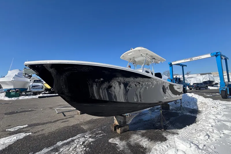 Slide: The Image of 2011 Regulator 28 Forward Seating boat on stands in snowy marina. - 5