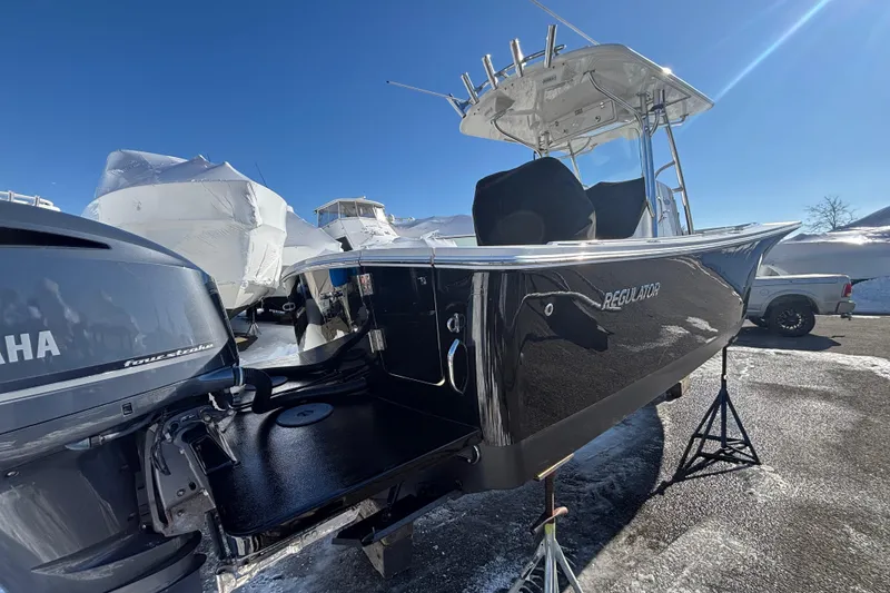 Slide: The Image of 2011 Regulator 28 Forward Seating boat with Yamaha engine, displayed outdoors on a sunny day. - 7