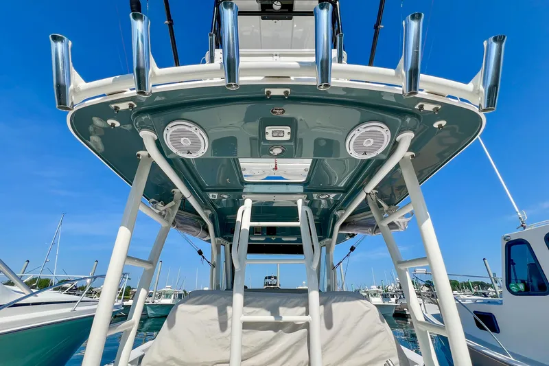 Slide: The Image of 2017 Everglades 355 Center Console boat with fishing rod holders and speakers, docked under clear skies. - 11