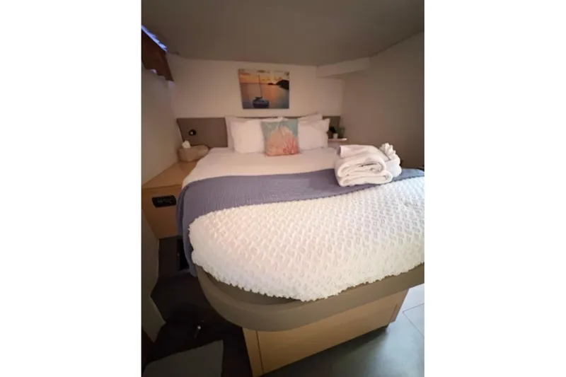 Slide: The Image of Cozy bedroom in 2015 Fountaine Pajot SABA 50 catamaran with neatly arranged bed linens. - 11