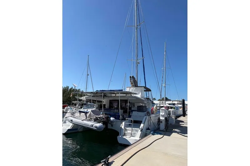 Slide: The Image of 2015 Fountaine Pajot SABA 50 catamaran docked at marina under clear blue sky. - 2