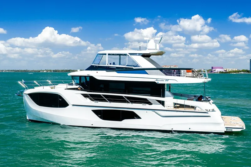 Slide: The Image of Luxury 2022 Absolute 64 Navetta yacht cruising on turquoise waters under a clear blue sky. - 14