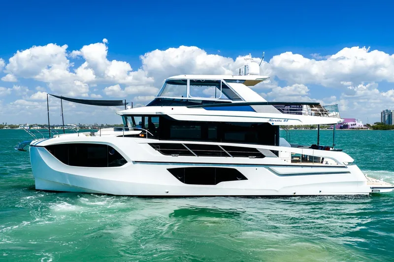Slide: The Image of Luxury 2022 Absolute 64 Navetta yacht cruising on clear blue waters. - 13