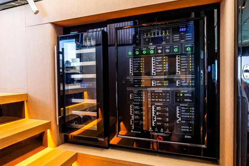 Slide: The Image of Electrical panel and wine cooler on 2022 Absolute 64 Navetta yacht interior. - 81