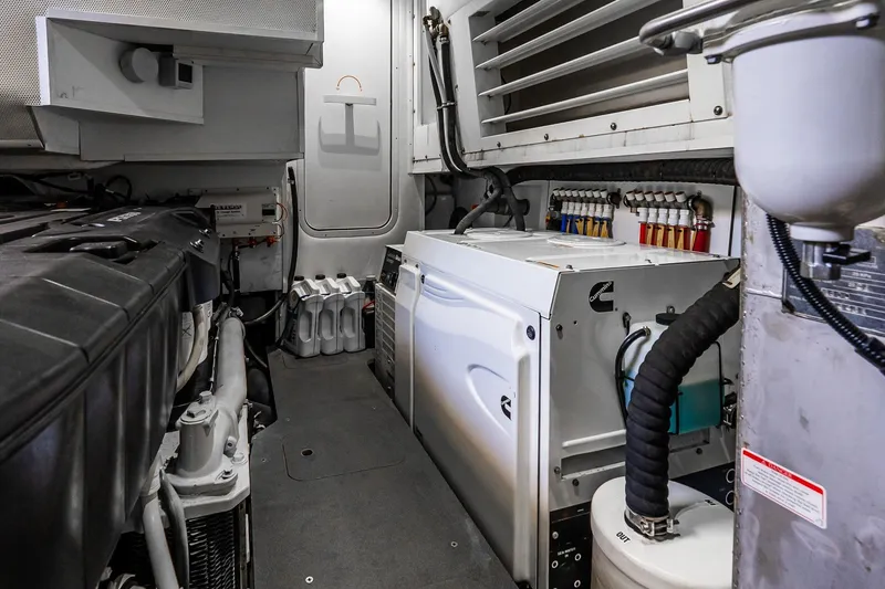Slide: The Image of Engine room of 2022 Absolute 64 Navetta yacht, featuring Cummins generator and organized piping. - 106