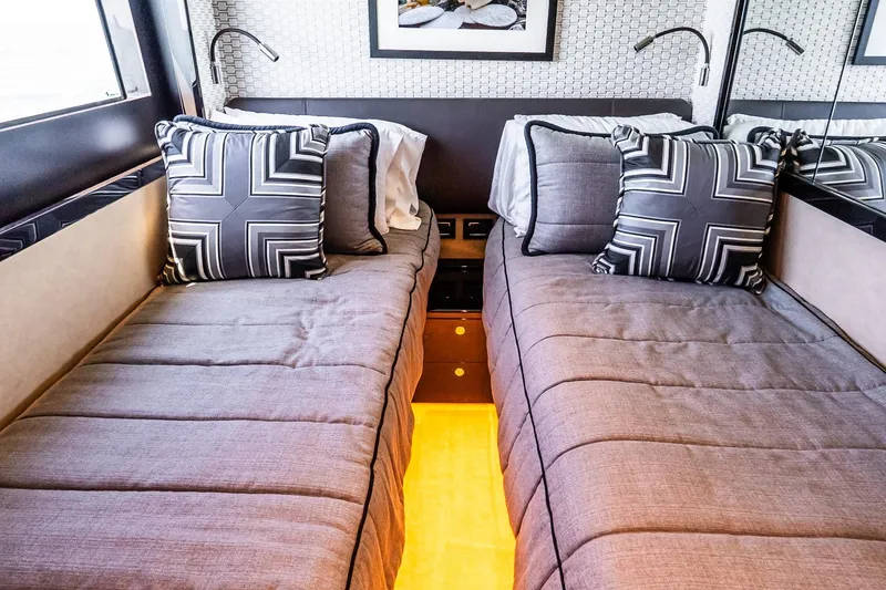 Slide: The Image of Luxurious twin cabin interior on 2022 Absolute 64 Navetta yacht, featuring elegant bedding and decor. - 97