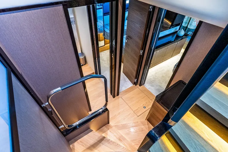Slide: The Image of Interior of 2022 Absolute 64 Navetta yacht, featuring elegant wooden stairs and modern design. - 82