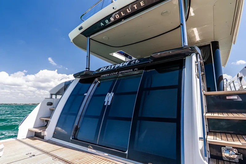 Slide: The Image of Luxury Absolute 64 Navetta yacht, 2022 model, docked with clear blue skies and ocean. - 53