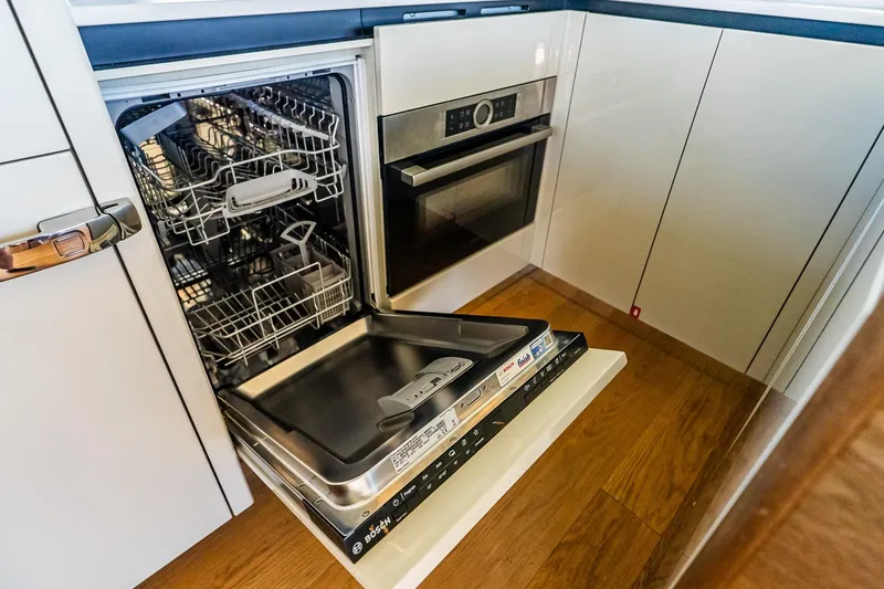 Slide: The Image of Modern kitchen with open dishwasher and oven on Absolute 64 Navetta yacht, 2022 model. - 67