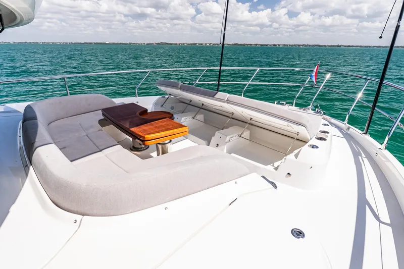 Slide: The Image of Luxurious 2022 Absolute 64 Navetta yacht deck with seating and table, overlooking serene ocean waters. - 27