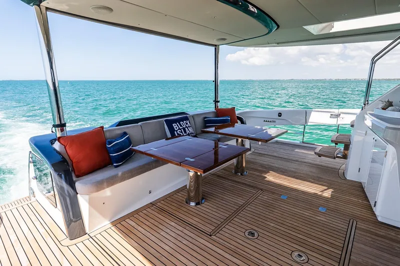 Slide: The Image of Luxurious 2022 Absolute 64 Navetta yacht deck with seating, ocean view, and elegant wood flooring. - 61