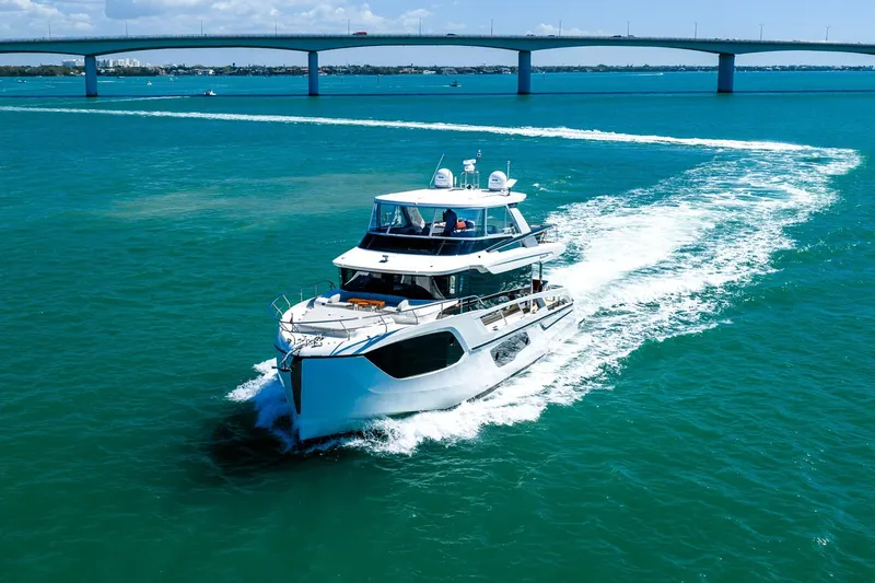Slide: The Image of Luxury yacht Absolute 64 Navetta 2022 cruising under a bridge on clear blue waters. - 20